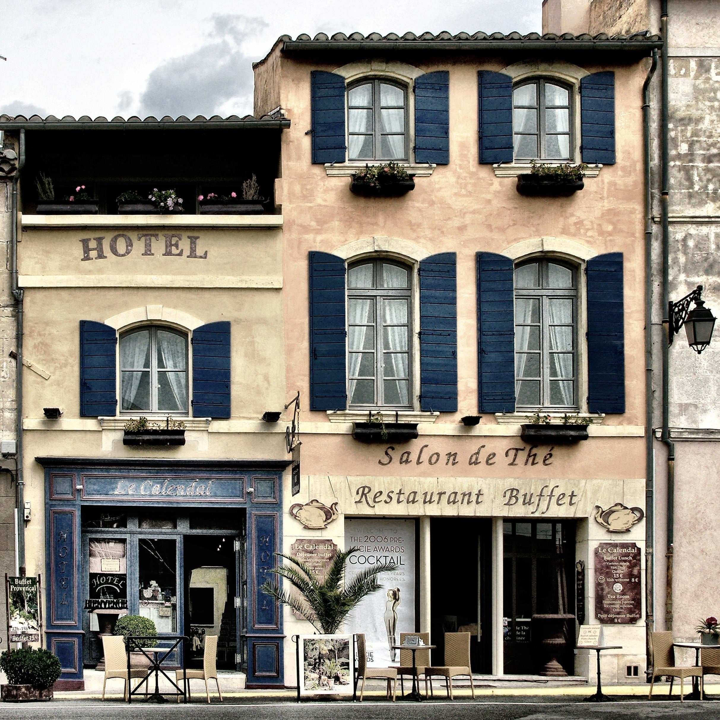Hotelfacade med blå skodder og restaurant i stueetagen